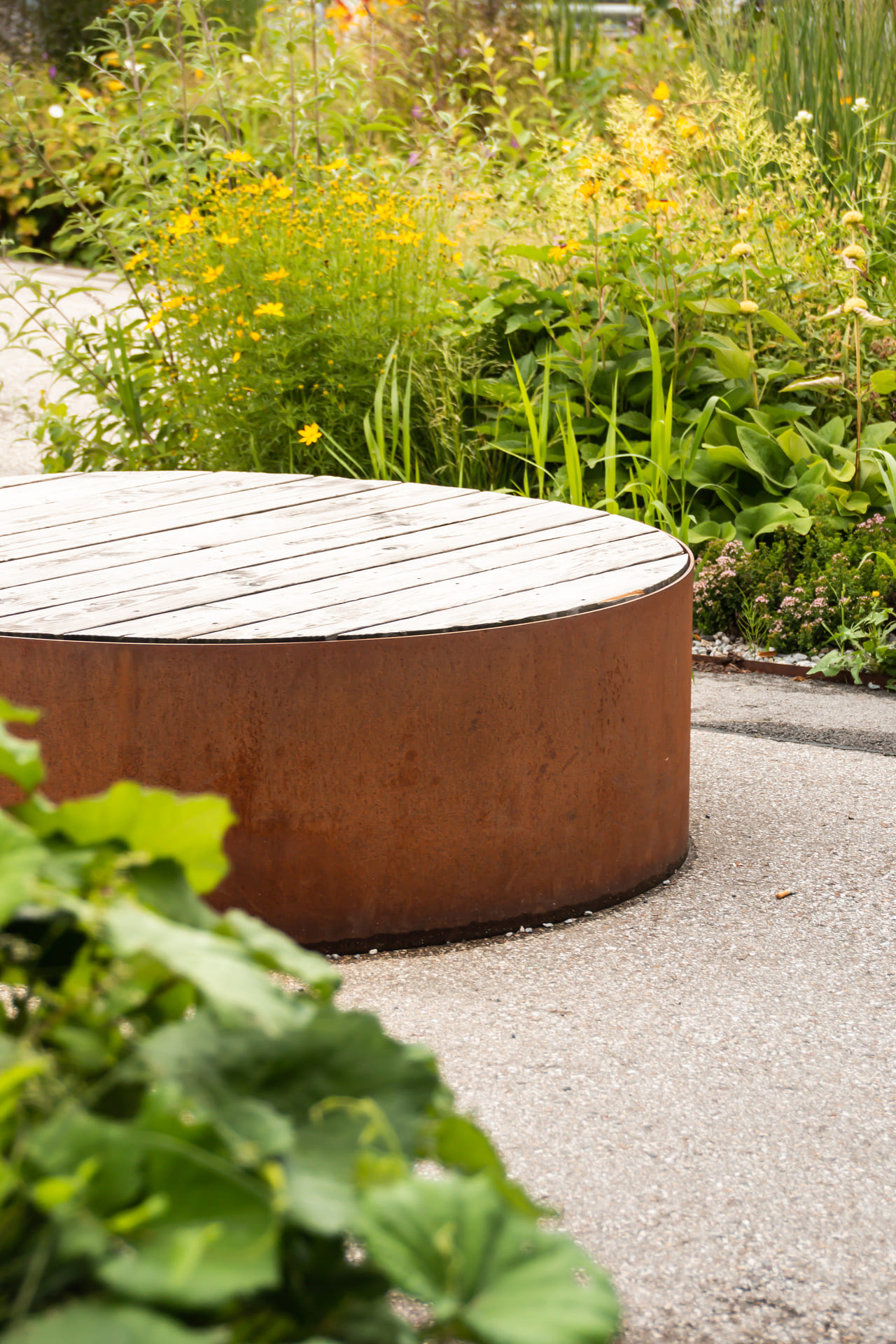 Sitzgelegenheit aus Holz und Metall in einem Garten