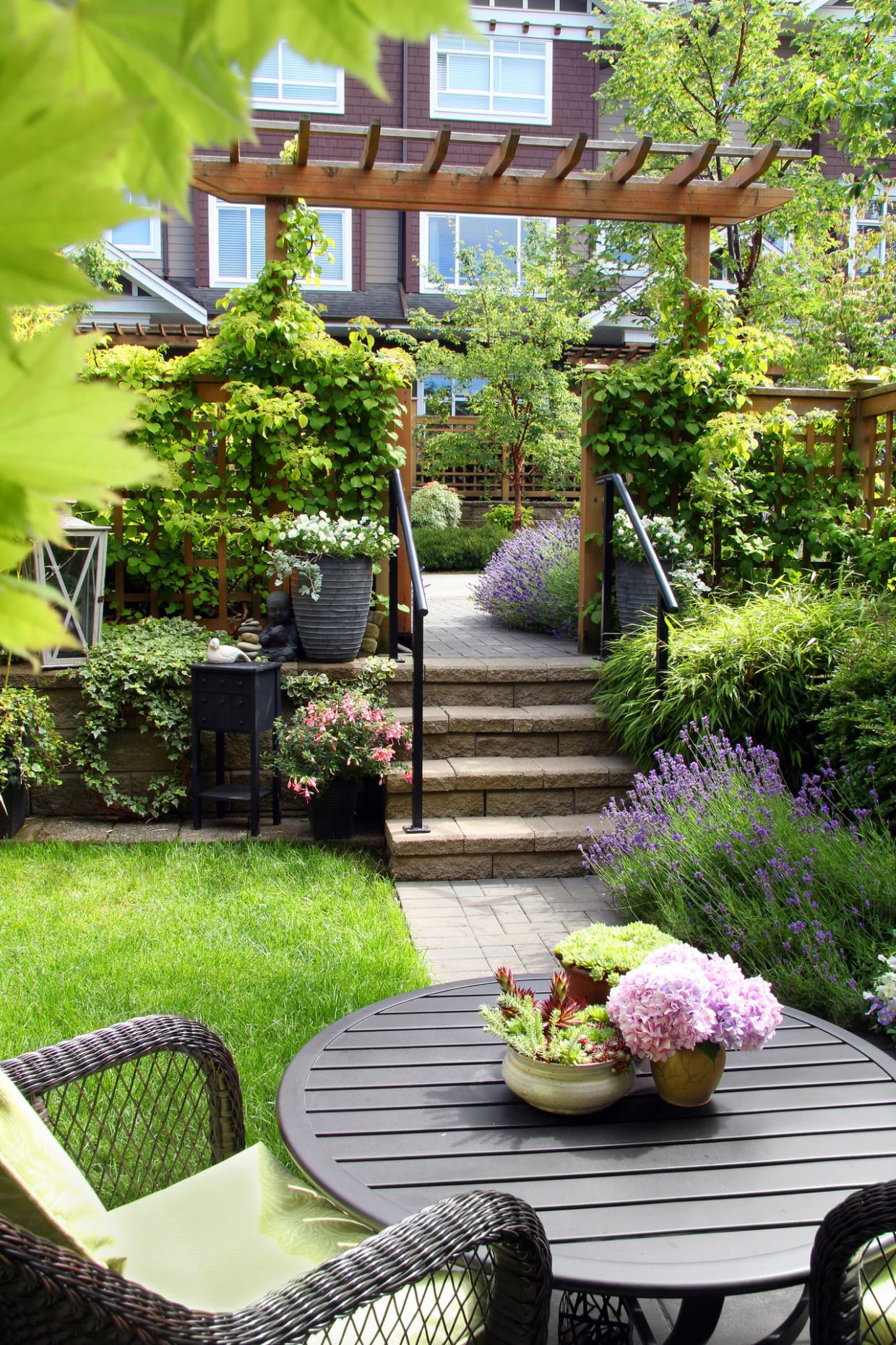 Blick aus Garten auf Terrasse, dazwischen kleine Treppe mit 4 Stufen