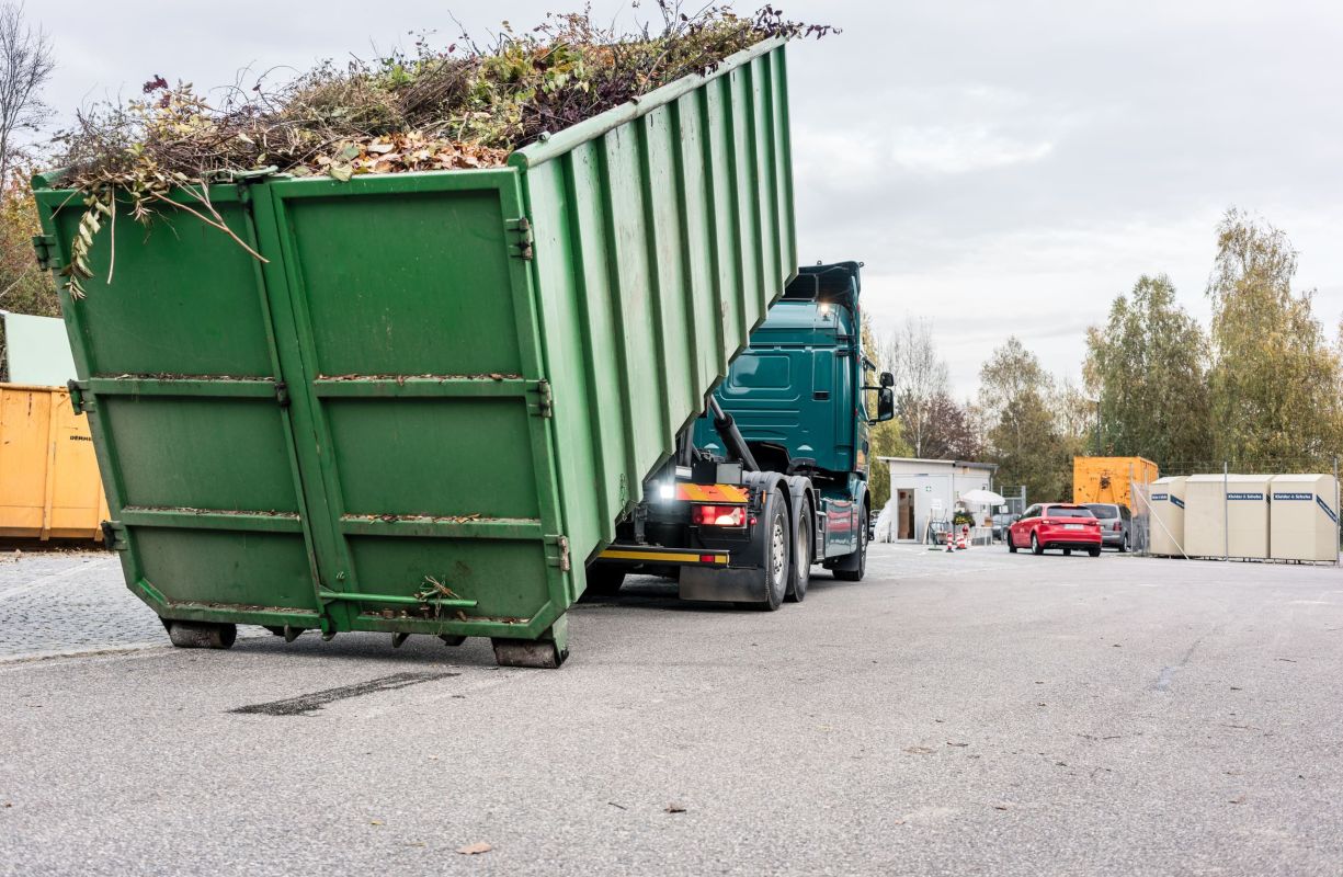 Container voll mit Grünschnitt wird aufgladen