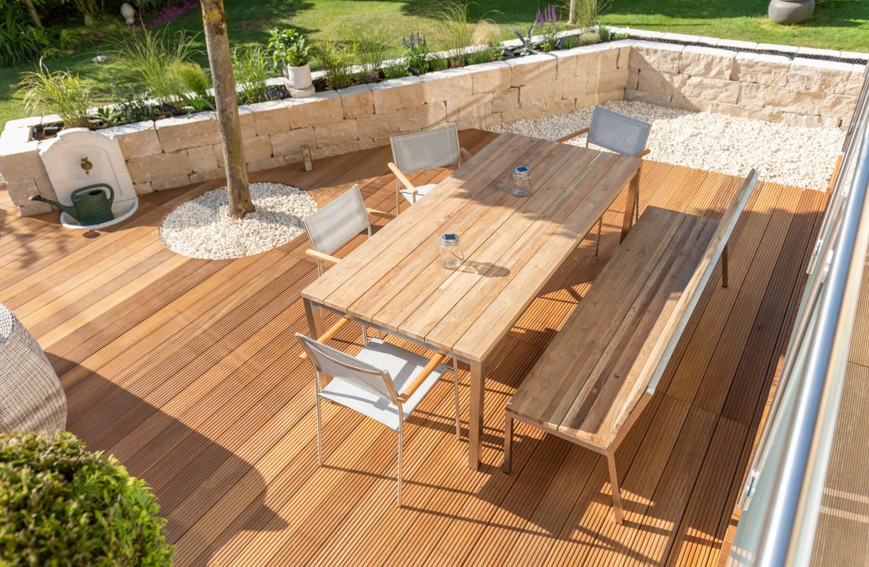 Hözerne Terrasse umgeben von Sandsteinmauer